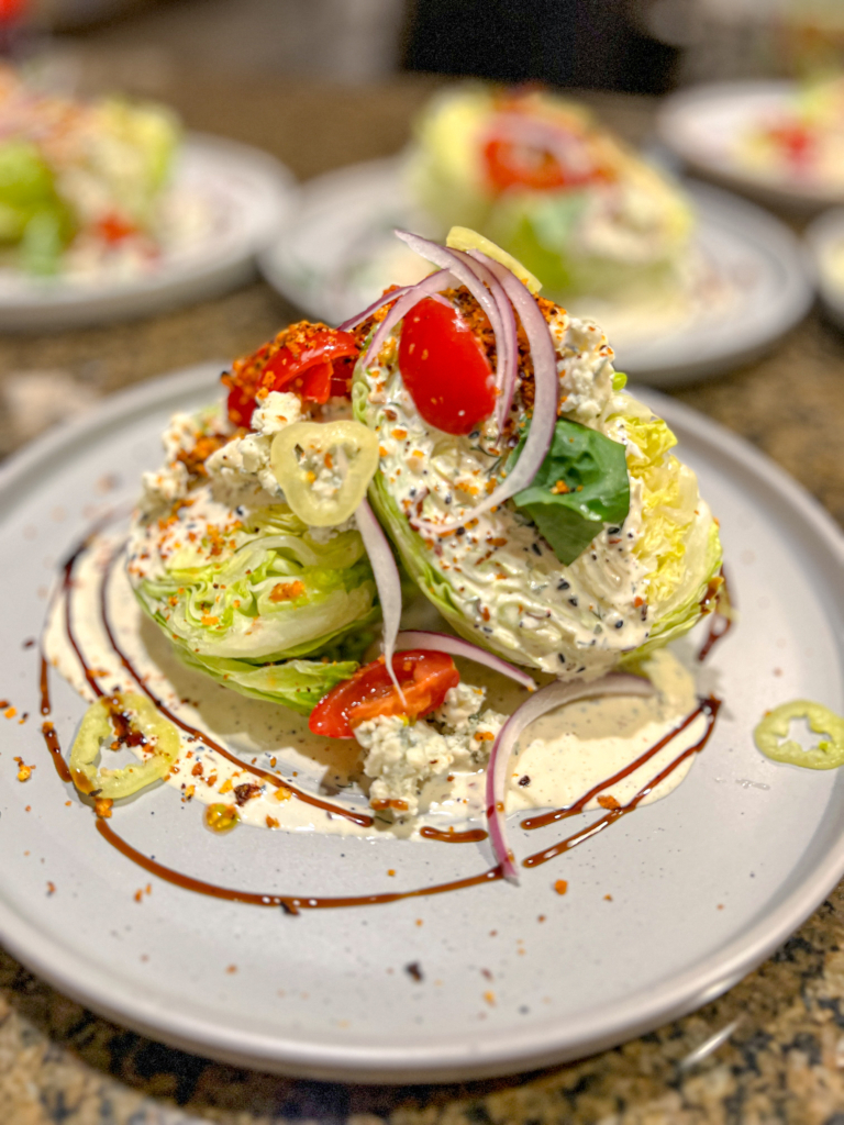 The Italian iceberg wedge from FEAST Bham is one of four courses in their Valentine's Day meal kit for two. It comes with gorgonzola, a balsamic glaze, slow-roasted tomatoes, banana peppers, shaved red onion, fresh basil and a breadcrumb topping. (Photo provided by Lindsey Noto King) 